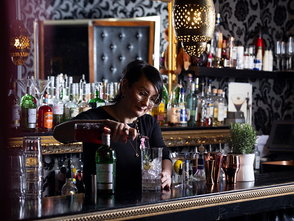 Henkilö tekee drinkkiä baarissa