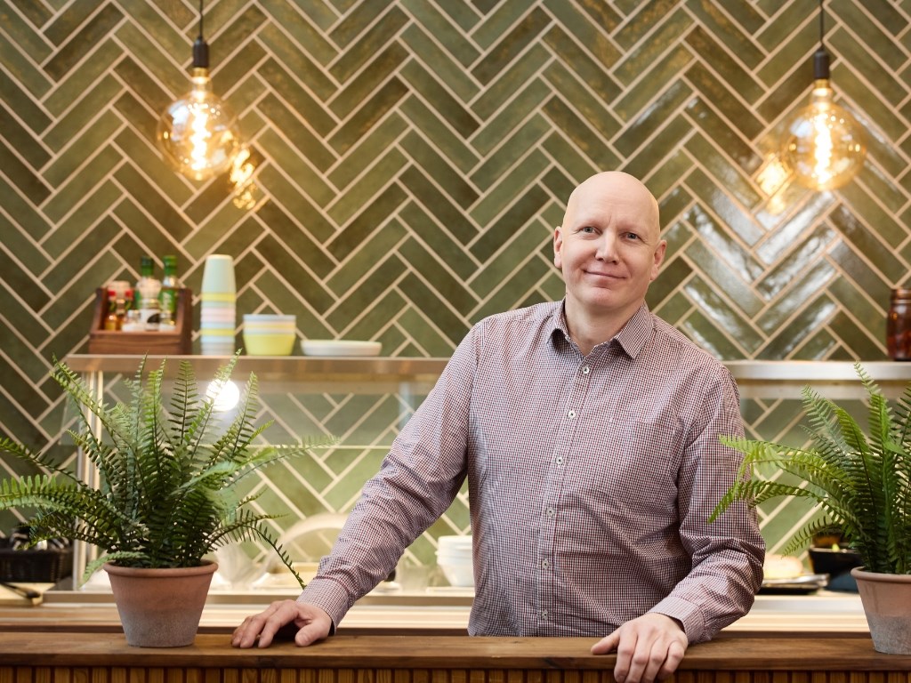 Hymyilevä henkilö tiskin takana