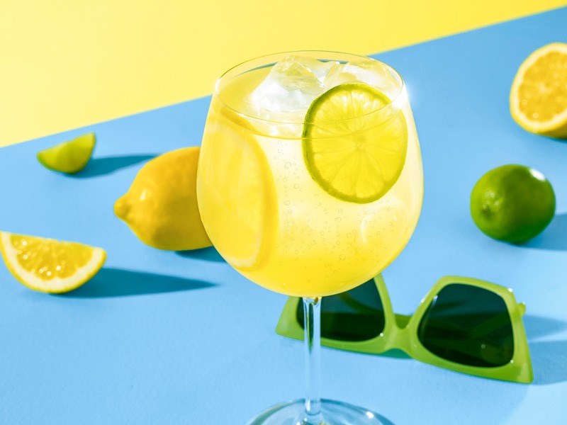 Sitruksinen RTD-juoma tarjoiltuna korkeasta viinilasista.