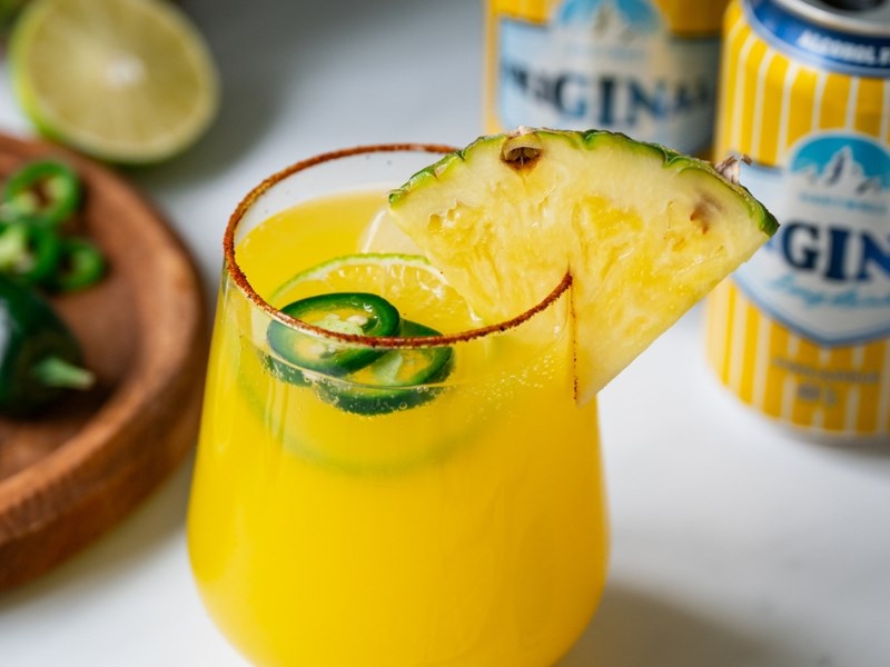 Lasiin valmistettu ananasdrinkki, jossa on tuoretta ananasta ja jalapenoa koristeena.